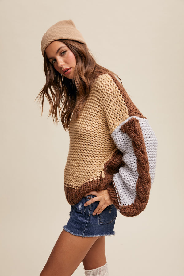 Woman wearing a brown and beige sweater with denim shorts on a beige background