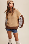 Woman wearing a beige and brown sweater with denim shorts on a beige background