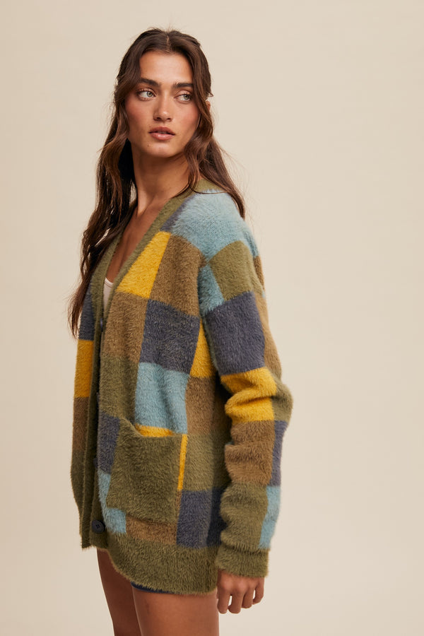 Woman wearing a colorful patchwork cardigan on a beige background