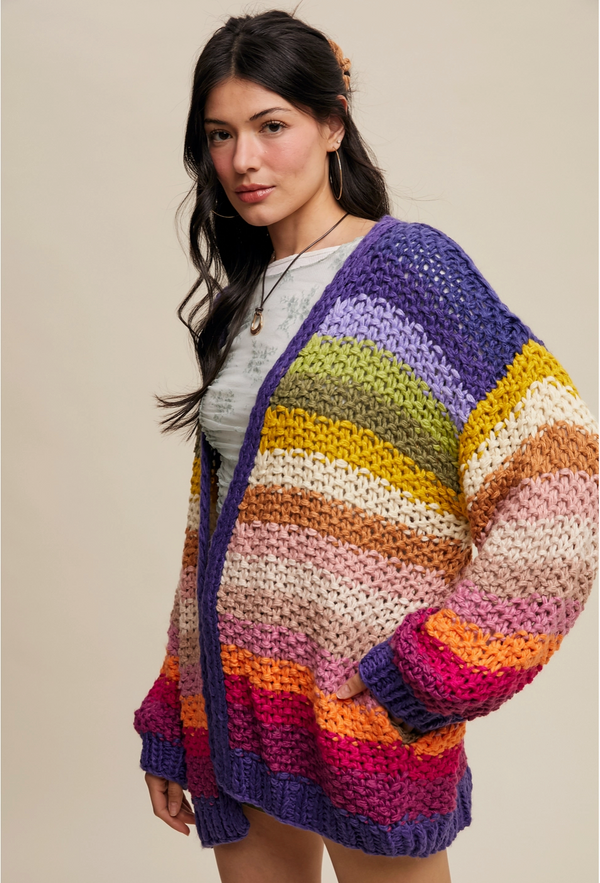 Woman wearing a colorful striped sweater against a beige background