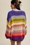 Woman wearing a colorful striped sweater against a plain background