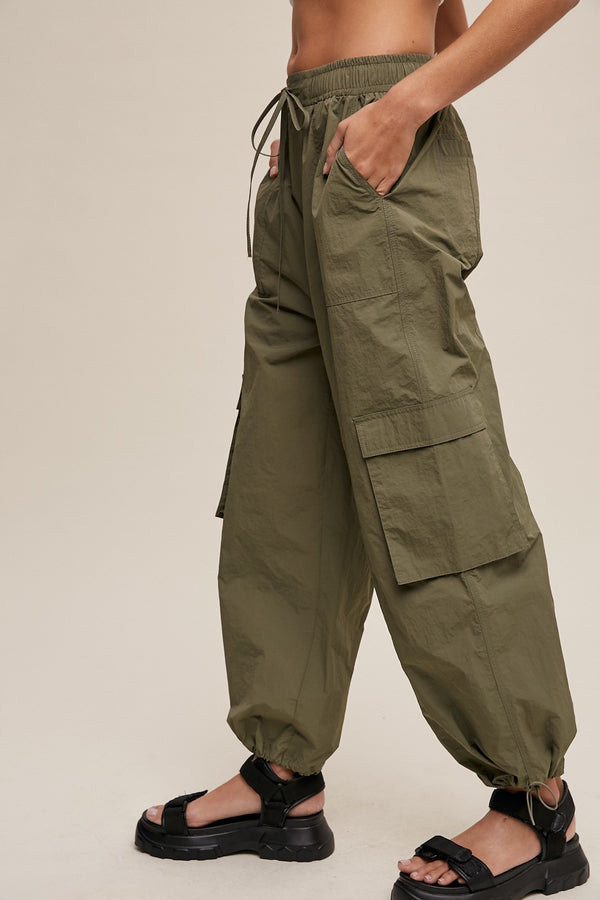 Green cargo pants worn by a person on a beige background