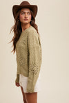 Woman wearing a green crochet sweater and brown hat on a beige background