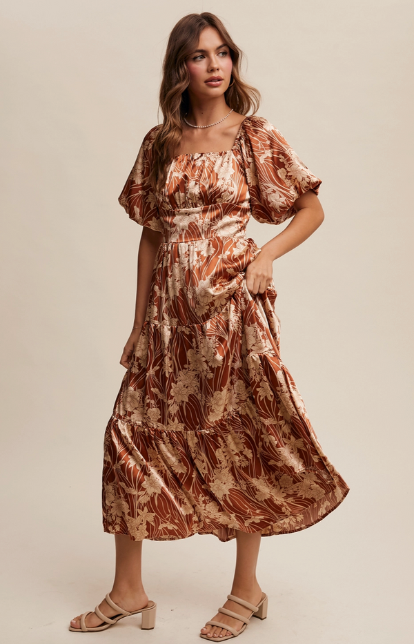 Woman wearing a patterned dress against a plain background