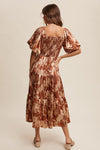 Woman wearing a patterned dress on a beige background