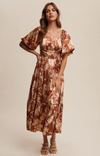 Woman wearing a floral dress against a plain background