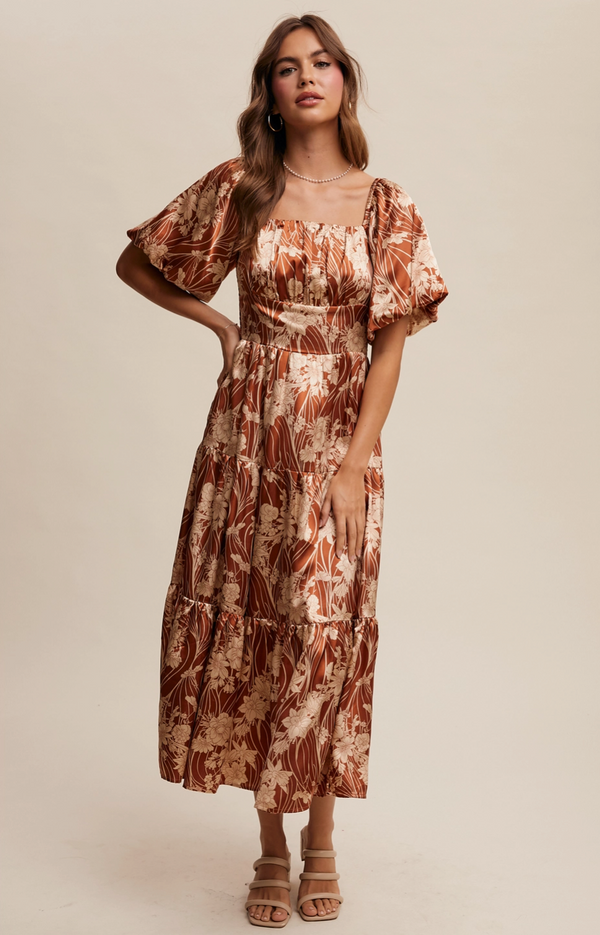Woman wearing a floral dress against a plain background