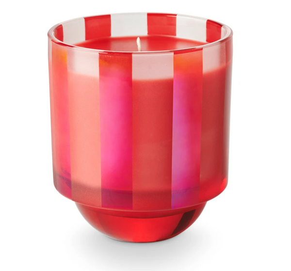 A boxed glass candle with red and pink stripes designed for holiday use.