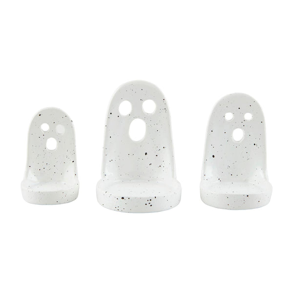A set of three white ceramic tea light holders with a ghost face design.
