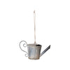 A distressed zinc finish metal watering can ornament with a hanging loop, designed for holiday decoration.