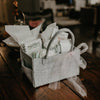 Gray gift basket with baby items on a wooden table