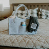 Gray tote bag with items on a bed
