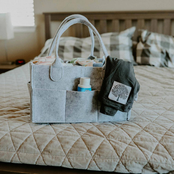Gray tote bag with items on a bed