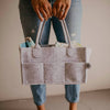 Person holding a gray felt tote bag with handles