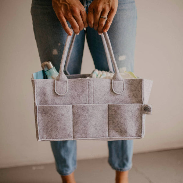 Person holding a gray felt tote bag with handles