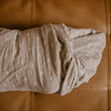 Folded beige fabric on a brown leather surface