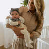 Woman holding a baby in a neutral setting
