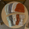 Set of baby hats and headbands on a wooden stool.