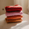 Stack of colorful towels on a light surface with a neutral background
