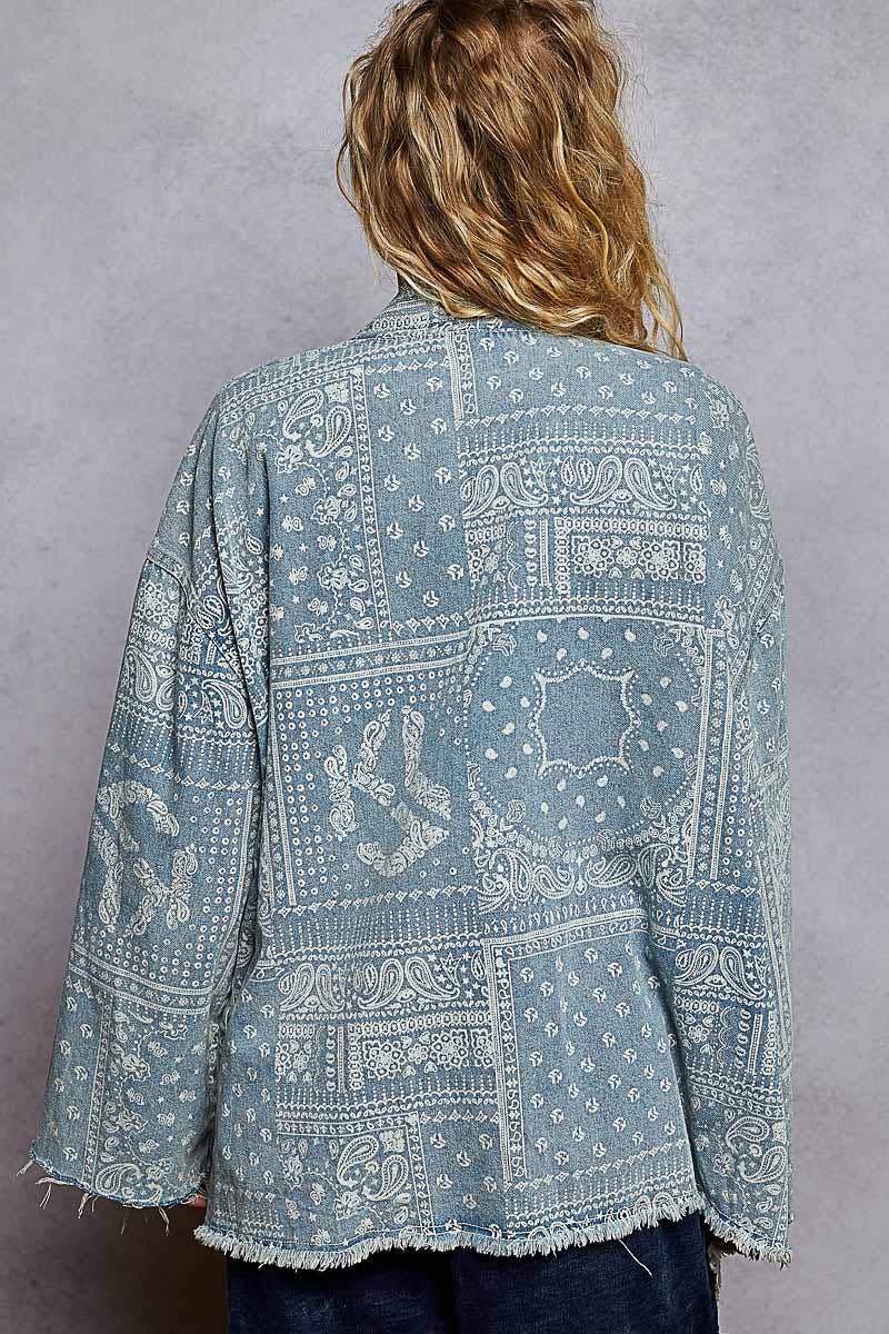 Person wearing a blue patterned jacket against a gray background