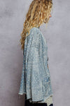 Woman wearing a light blue patterned kimono against a gray background