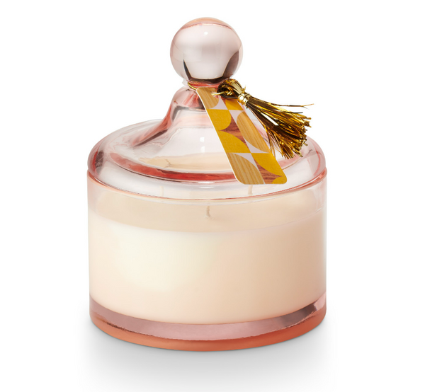 A clear glass candle with a decorative lid featuring a golden tassel, filled with a beige-colored wax, and labeled with 'Memory Lane'.