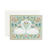 A wedding card with a natural white cover, featuring a printed design with swans, floral elements and the phrase 'Happy Forever After' on the front, accompanied by a soft white envelope.