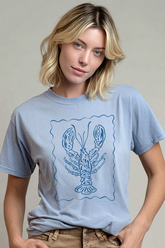 Woman wearing a light blue t-shirt with a lobster graphic on a plain background