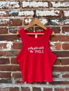 Red tank top with 'pretty girls watch the PHILS' text on a wooden hanger against a brick wall.