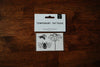 A pack of temporary tattoos featuring a coneflower and honeybees, placed on a wooden surface.