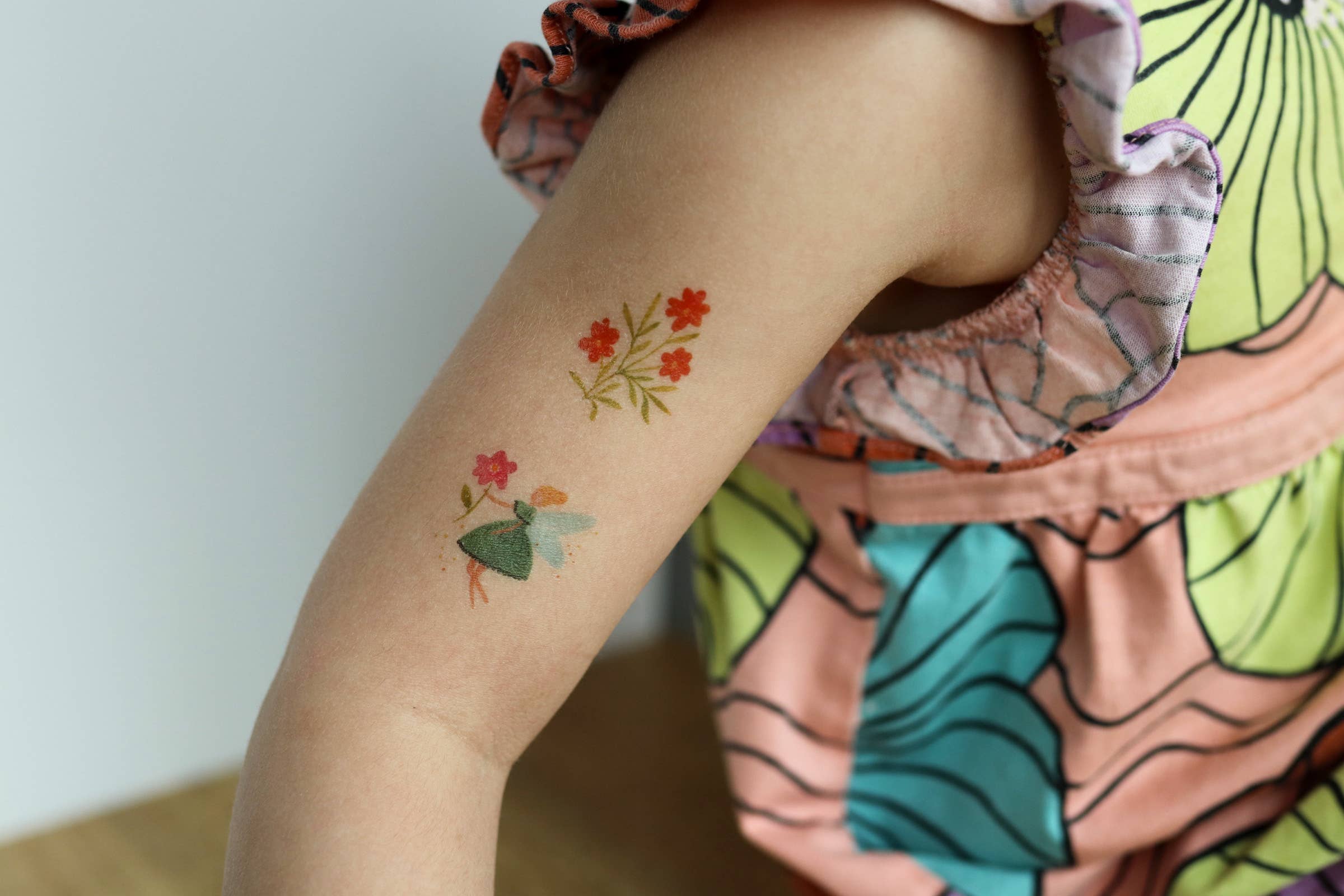 Temporary floral tattoos on a child's arm.