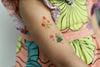 Temporary tattoo of a woman and flowers on a person's arm.
