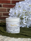 Jar of body cream with flowers and green fabric in the background
