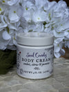Jar of Soul Candy body cream with white flowers in the background