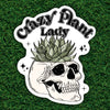 Sticker with skull and succulent design and 'Crazy Plant Lady' text on grass background