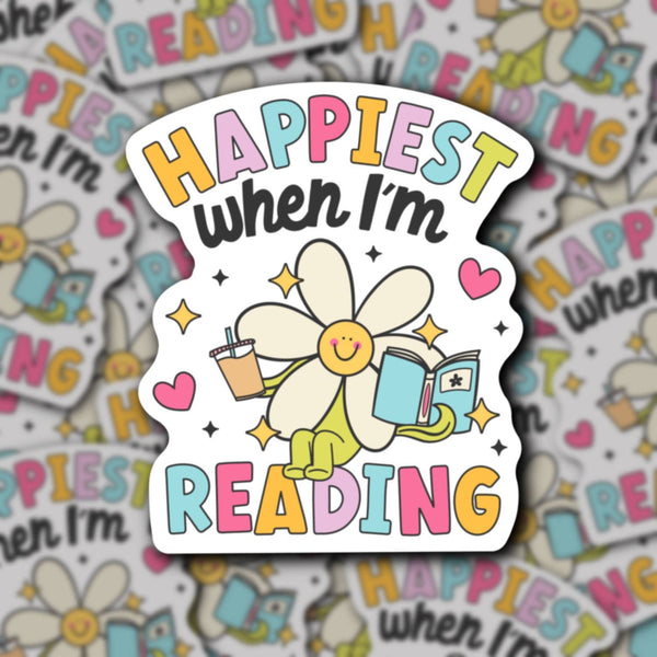 Colorful sticker with a cartoon character and text 'Happiest when I'm Reading' on a patterned background.