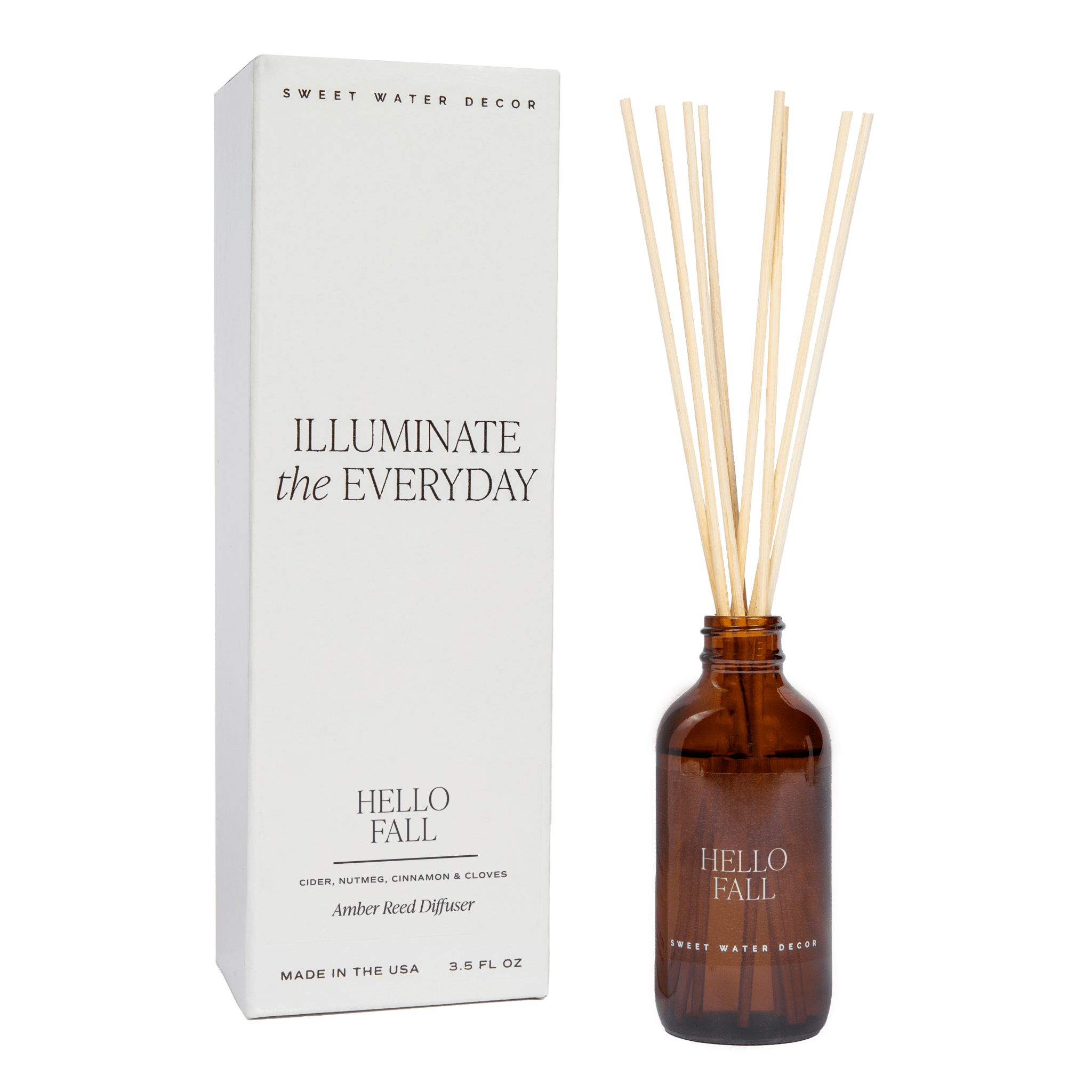 A brown glass reed diffuser bottle with 'Hello Fall' branding, alongside a white box packaging with the text 'Illuminate the Everyday'.