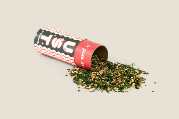 Spice container with spilled contents on a beige background