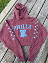 Maroon hoodie with 'PHILLY' and Liberty Bell design on a wooden surface