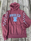 Maroon hoodie with 'PHILLY' and liberty bell graphic on a wooden surface
