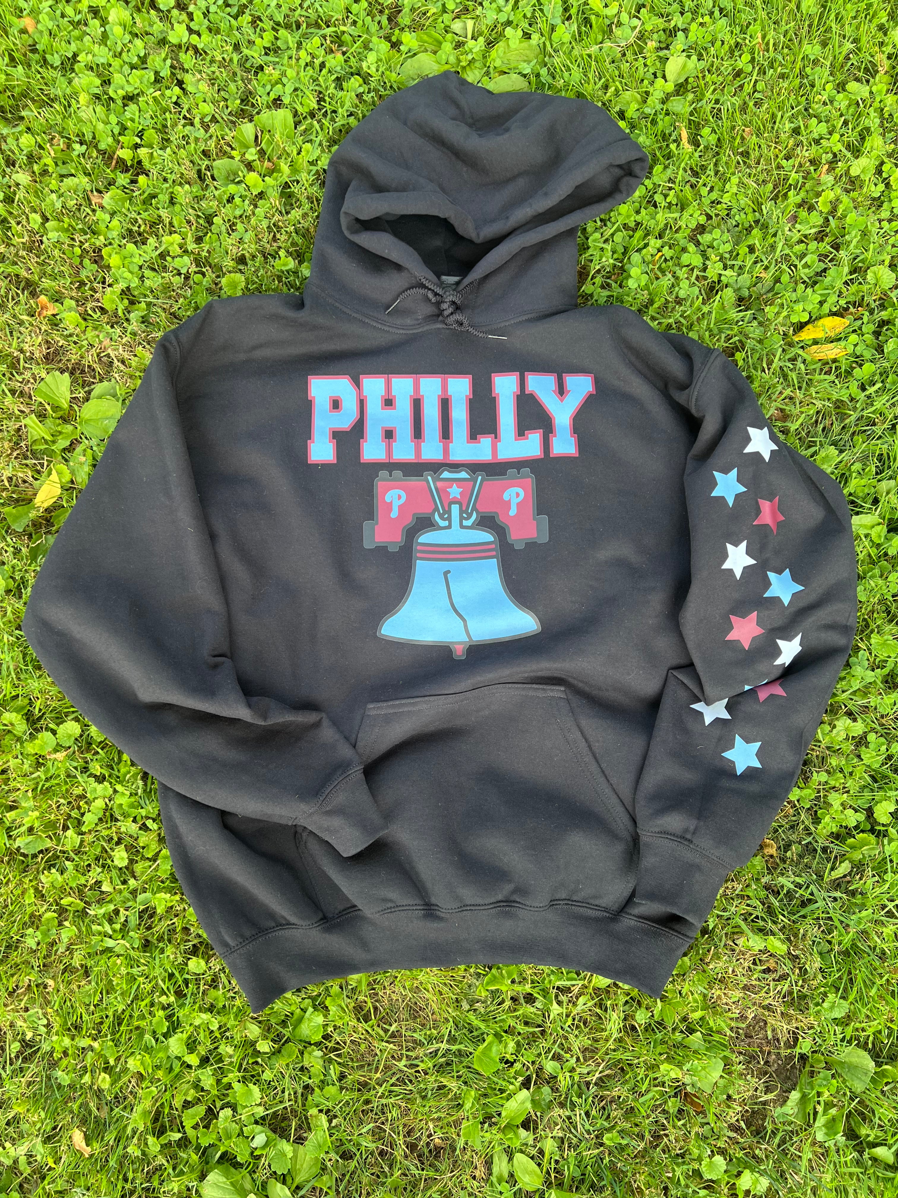 Black hoodie with 'PHILLY' and Liberty Bell design on grass