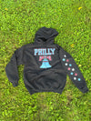 Black hoodie with 'PHILLY' and star designs on grass