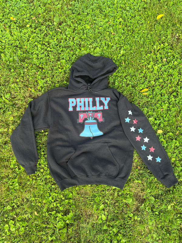 Black hoodie with 'PHILLY' and star designs on grass
