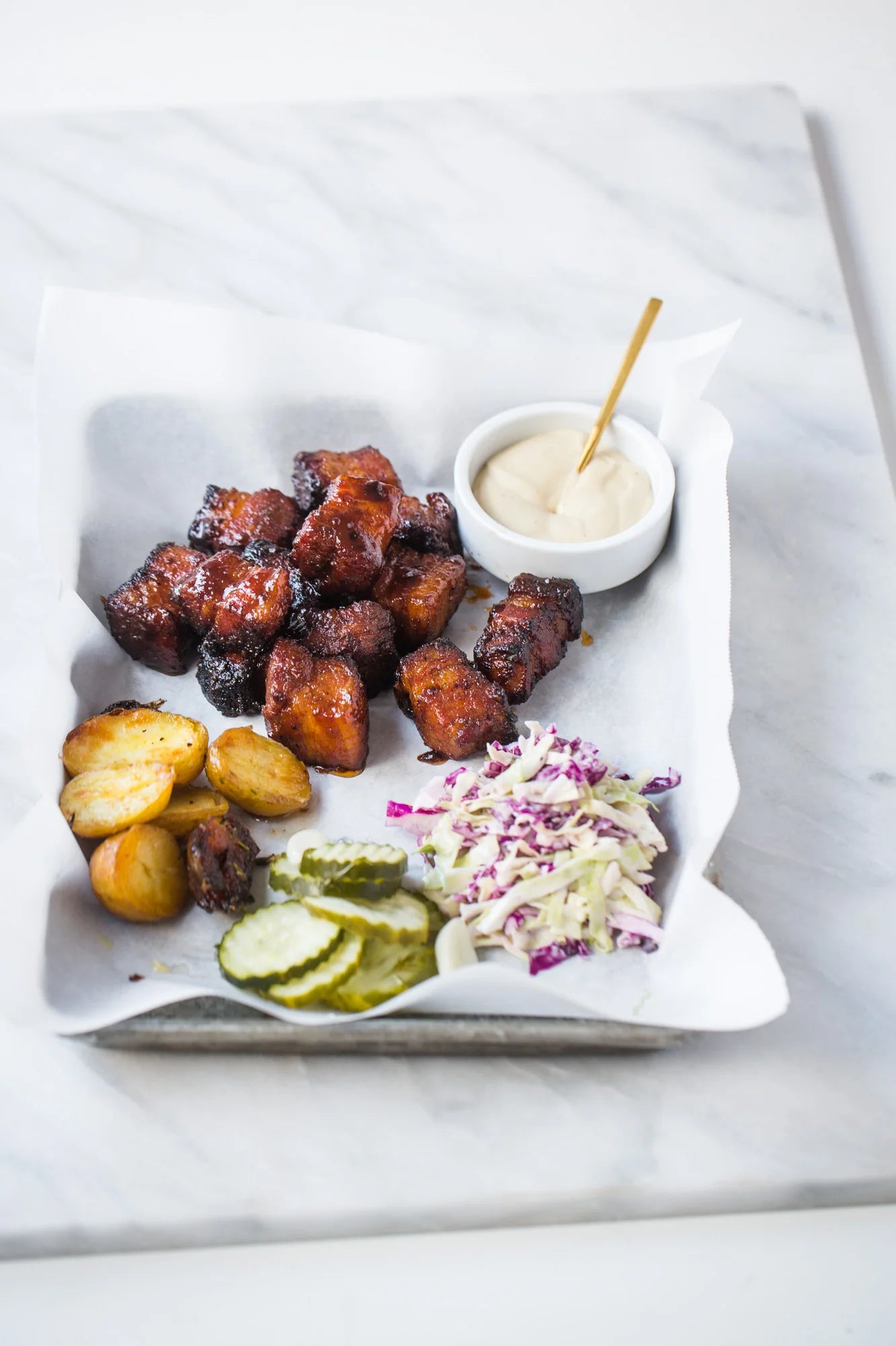 Platter of fried meatballs with sides on a white marble surface