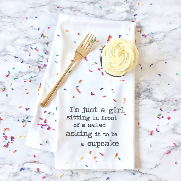 Towel with a cupcake graphic and text on a marble background with sprinkles