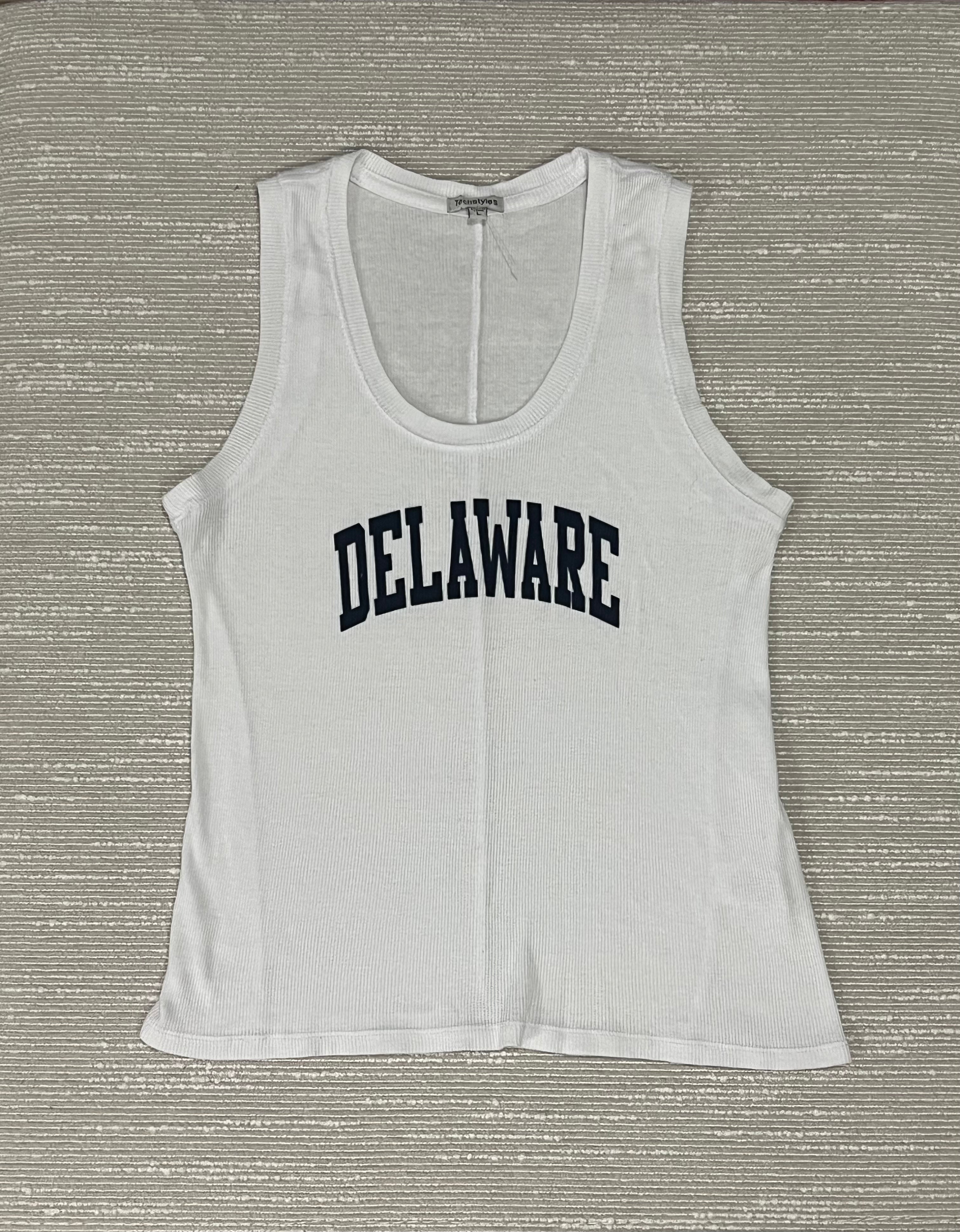 White tank top with 'DELAWARE' printed on it against a textured gray background