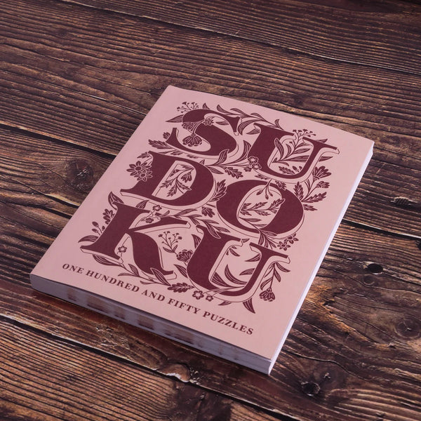 Sudoku book with decorative cover on a wooden surface