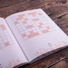 Open book with Sudoku puzzles on a wooden surface