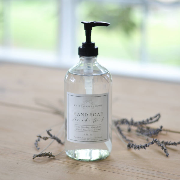 Hand soap bottle with pump on a wooden surface with lavender flowers.