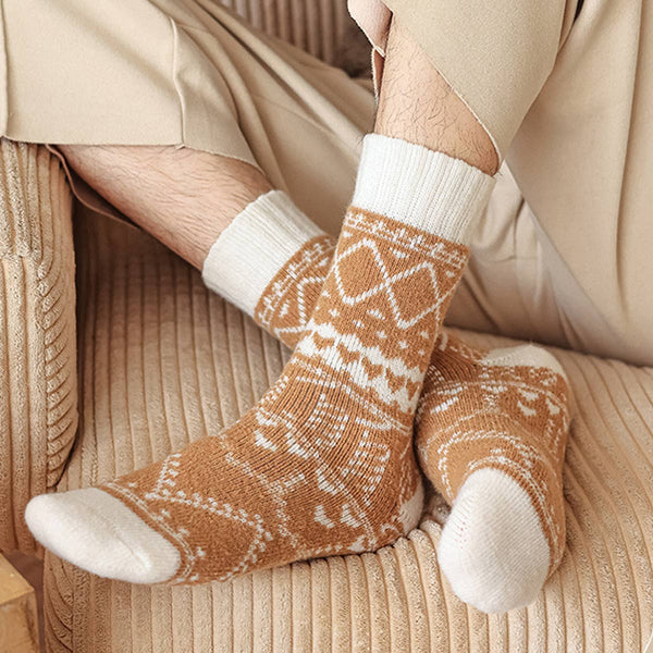 Person wearing brown and white patterned socks on a beige couch